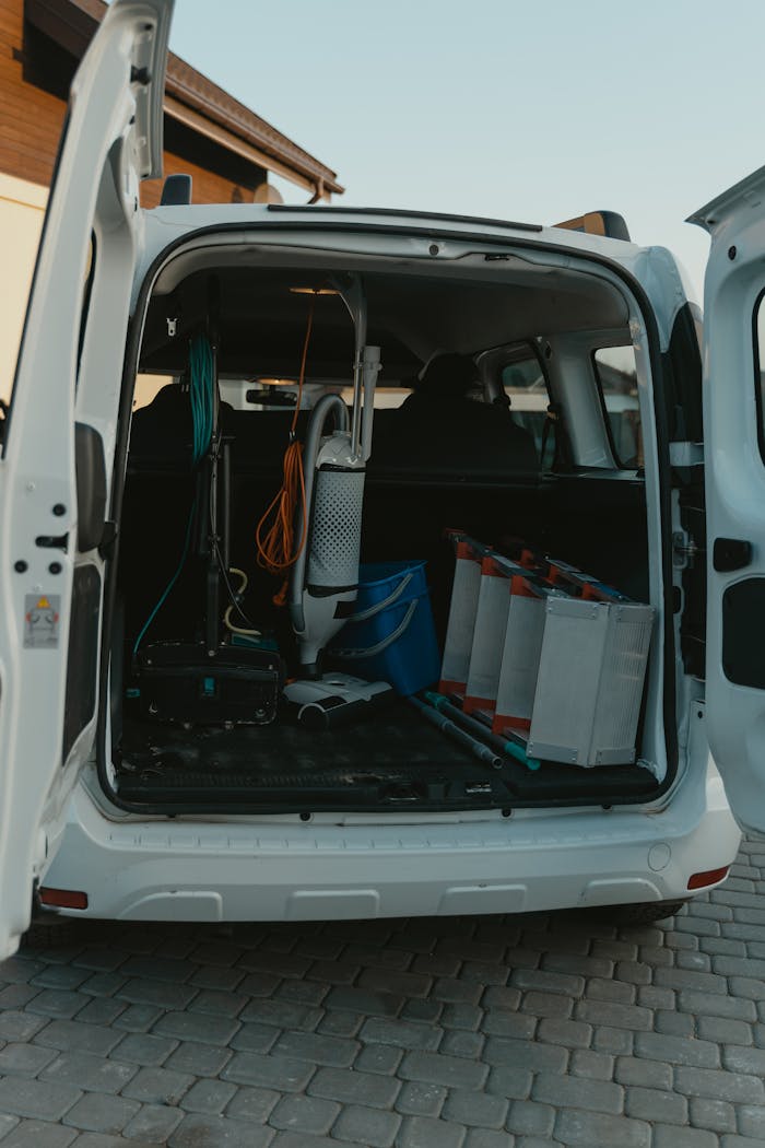 Rear view of open van showcasing cleaning equipment, ready for service.